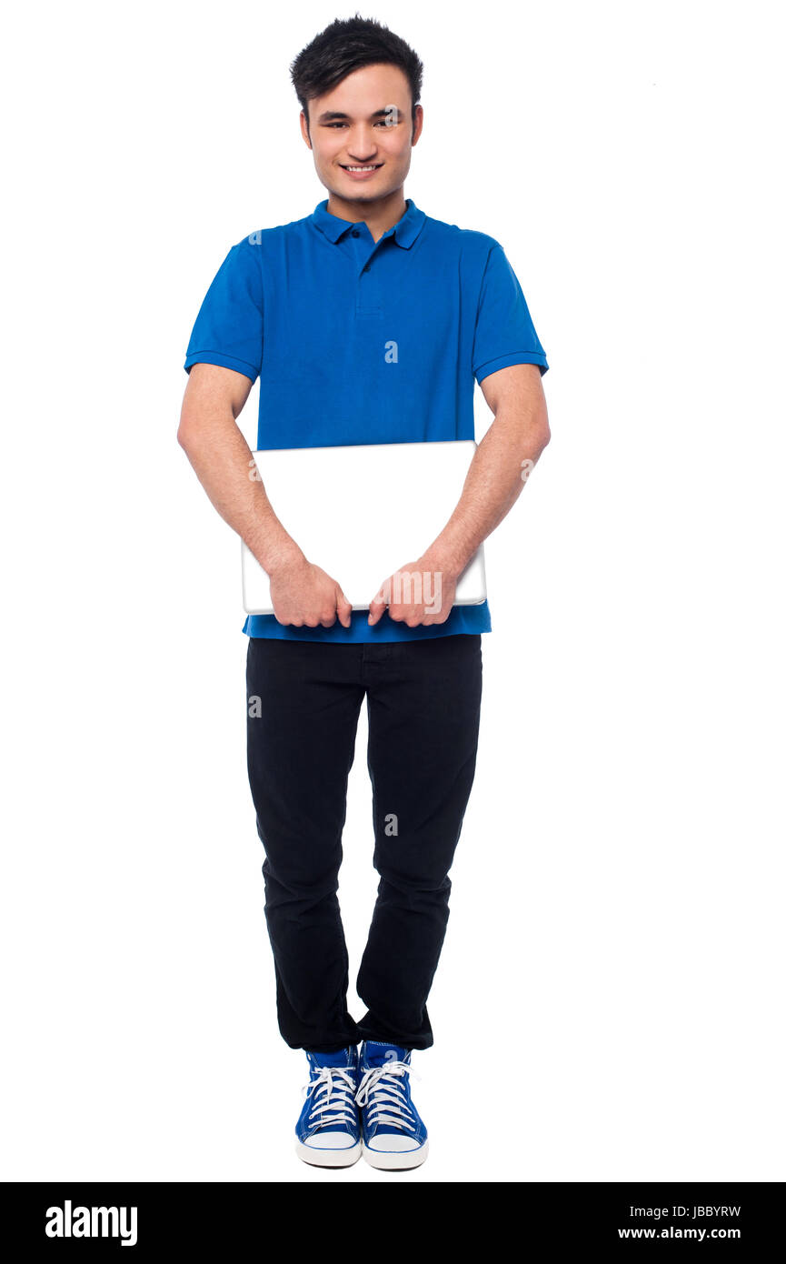 Full length studio shot of young guy posing with laptop Stock Photo