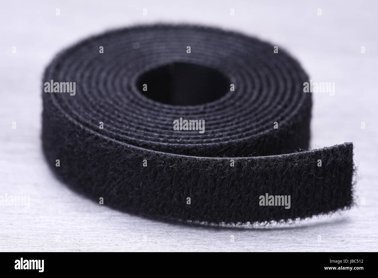 Roll of Velcro Tape on Gray Metal Surface Stock Photo