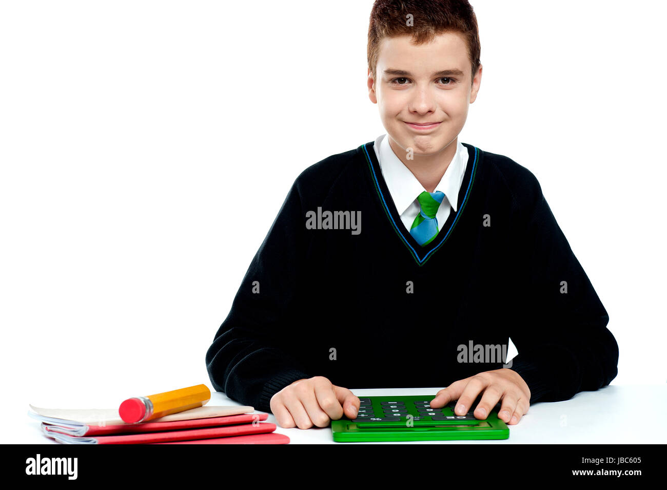 Smiling young boy using calculator sitting in classroom Stock Photo Alamy