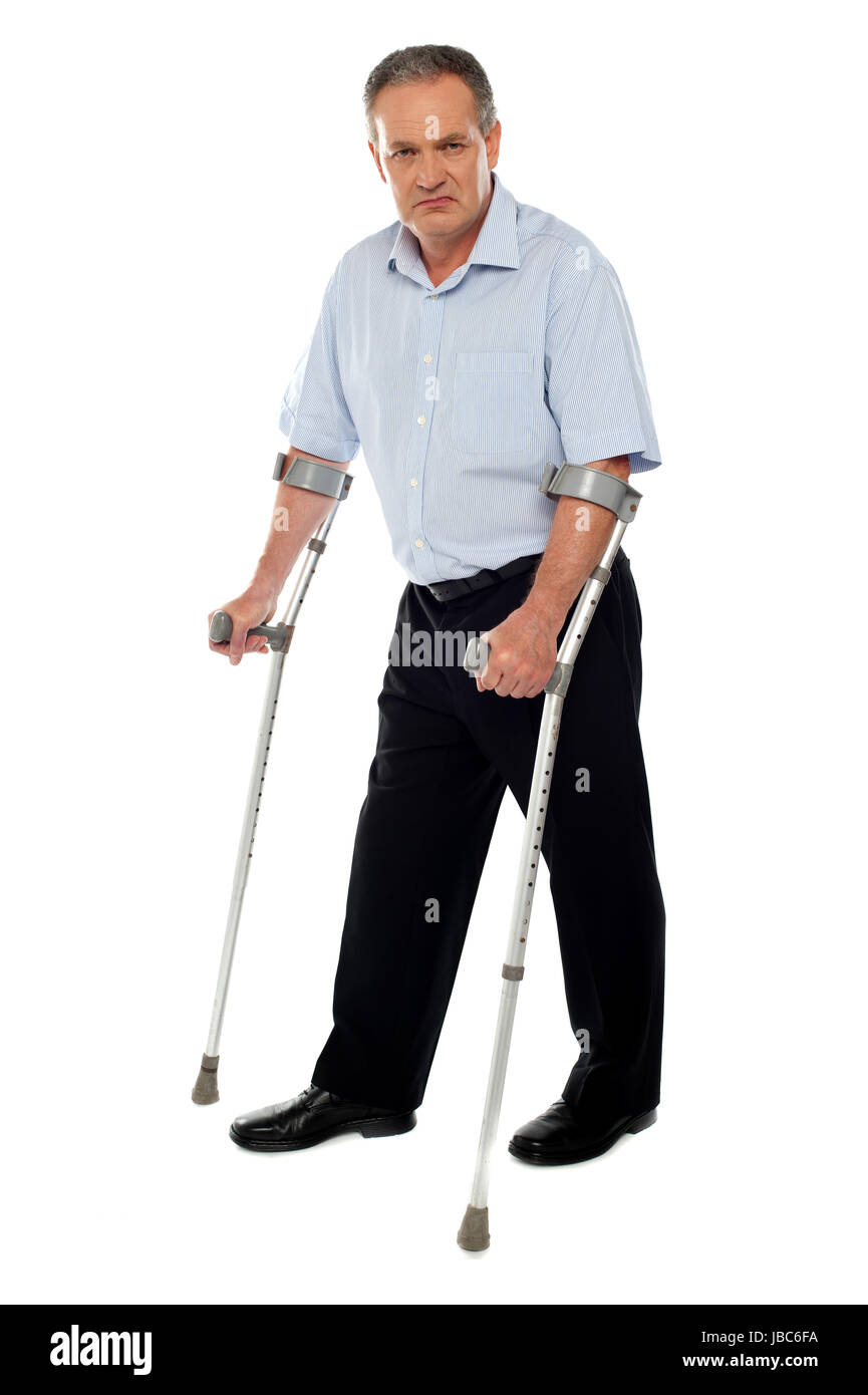 Old handicapped man with a walker standing against white background ...