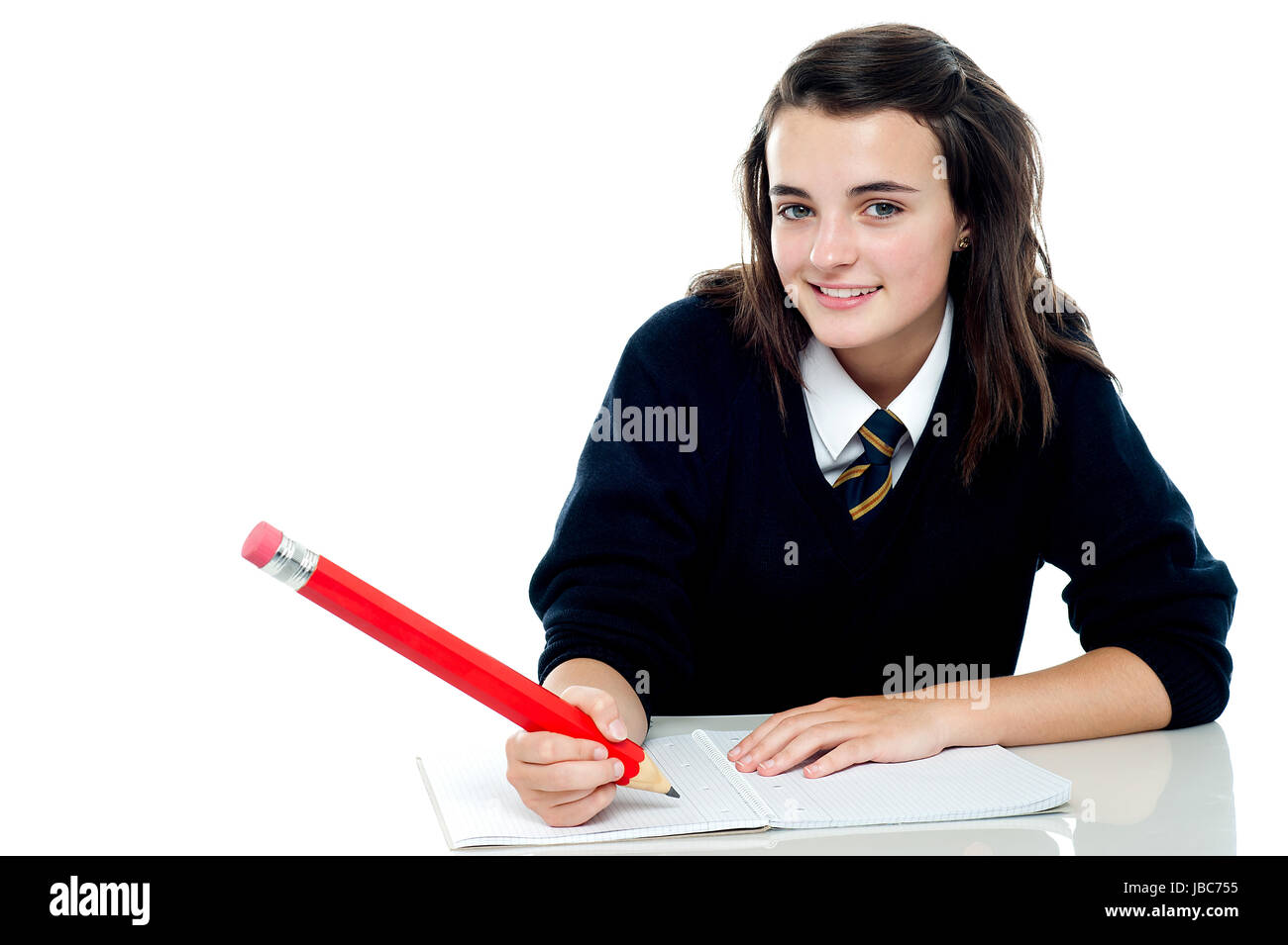 Confident school girl is ready to take up the test. Holding big red pencil Stock Photo
