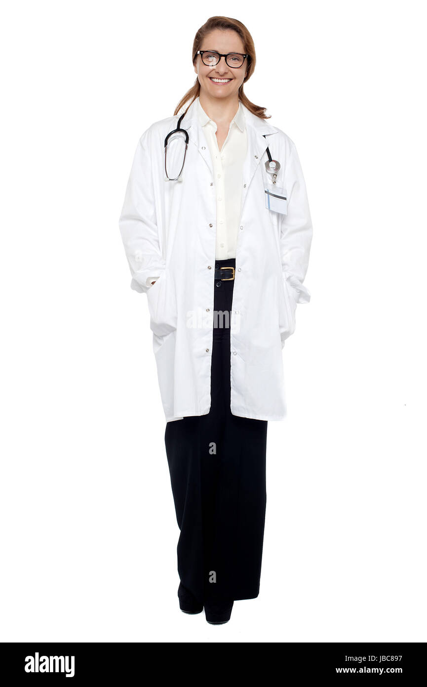 Full length portrait of a cheerful female doctor with hands in lab coat pocket. Stock Photo
