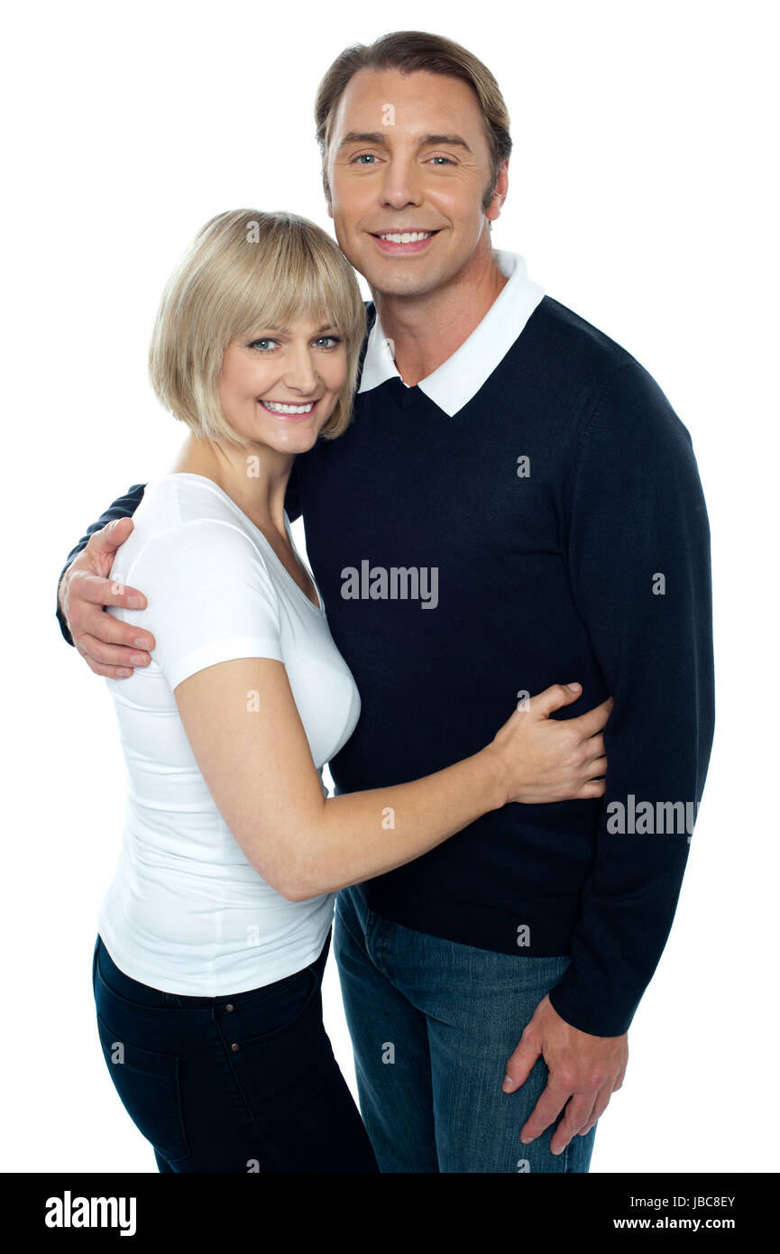 Stylish man in pullover embracing his blonde wife. Both smiling at the