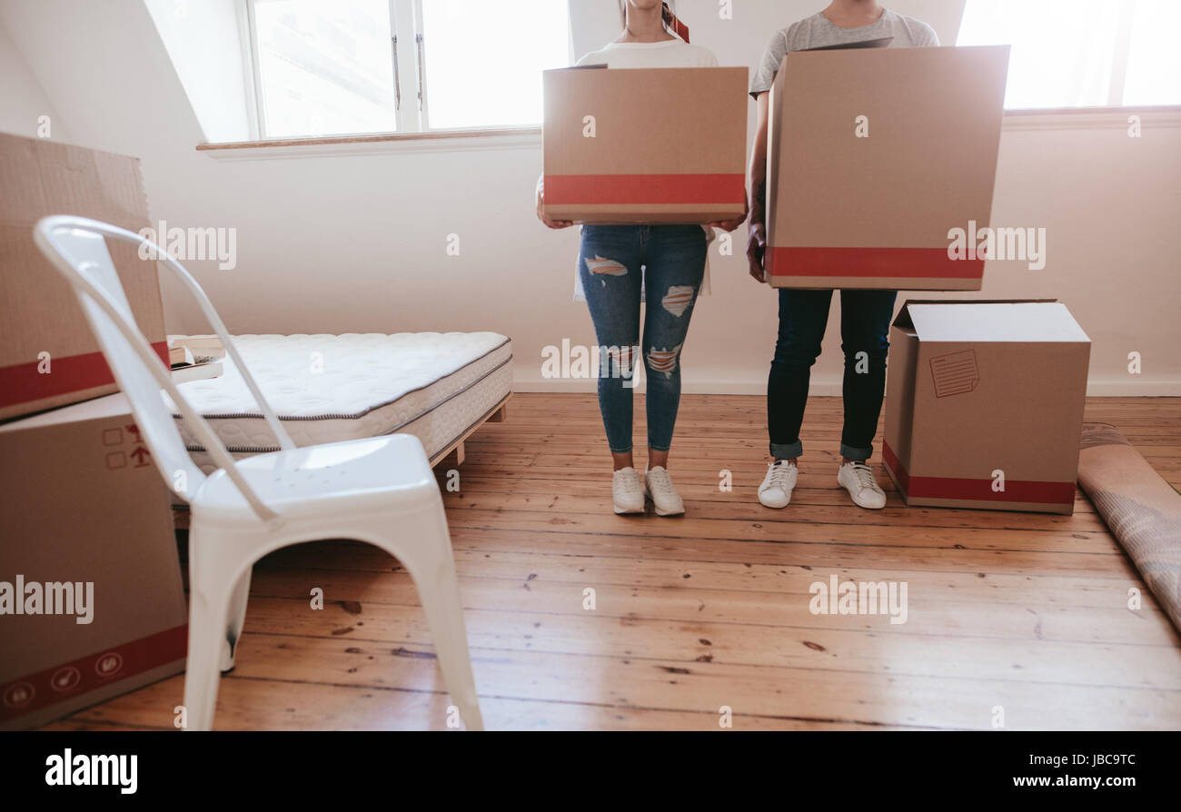 Cropped shot of young couple with big cardboard boxes moving to new ...