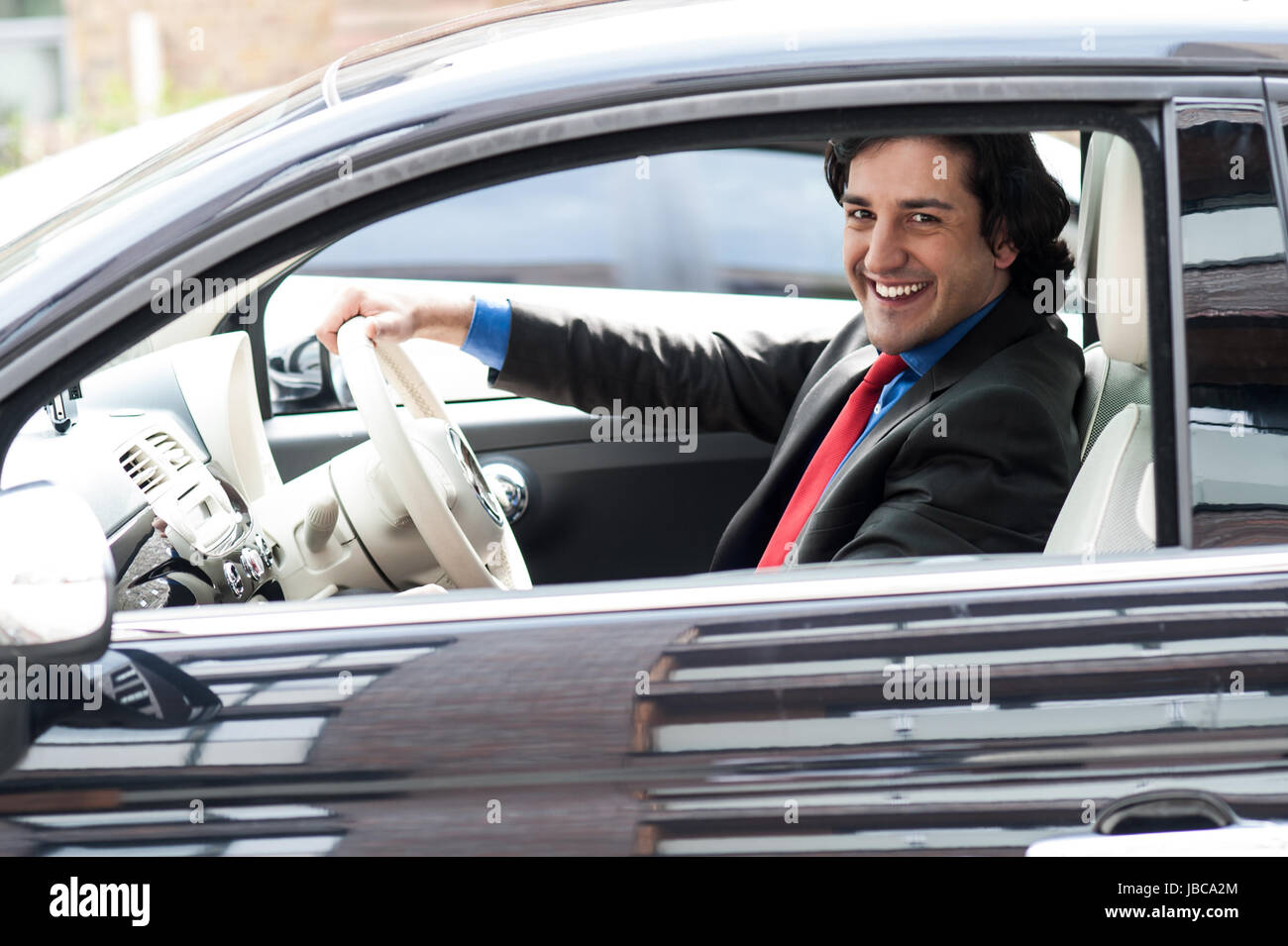 Mike drives an expensive new silver. За рулем профессионал. Бизнесмен в машине. Большой автомобильный босс. Stock young businessman in car