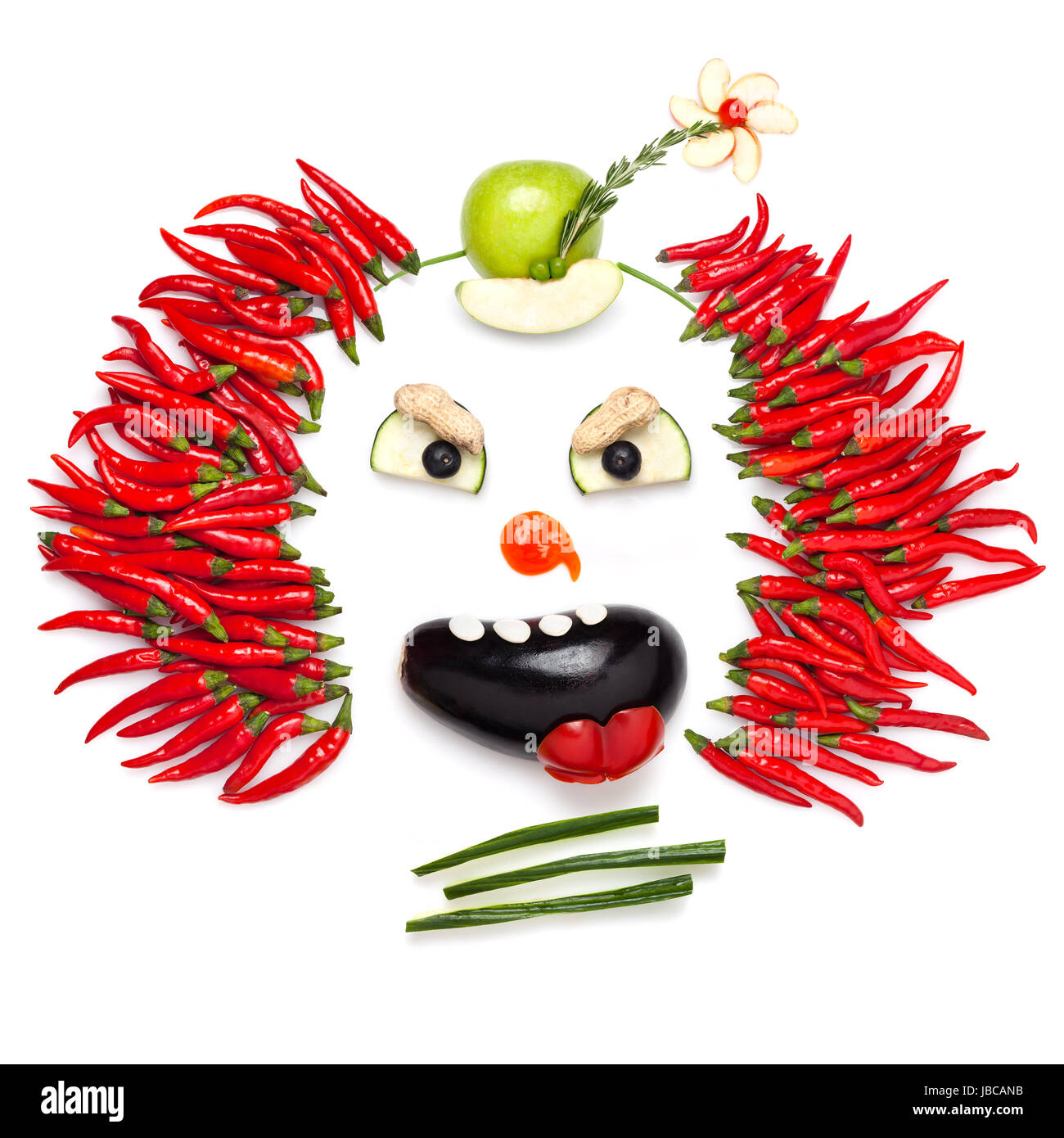A creative food concept demonstrating a creepy halloween clown with the help of chilli pepper and other vegetables. Stock Photo