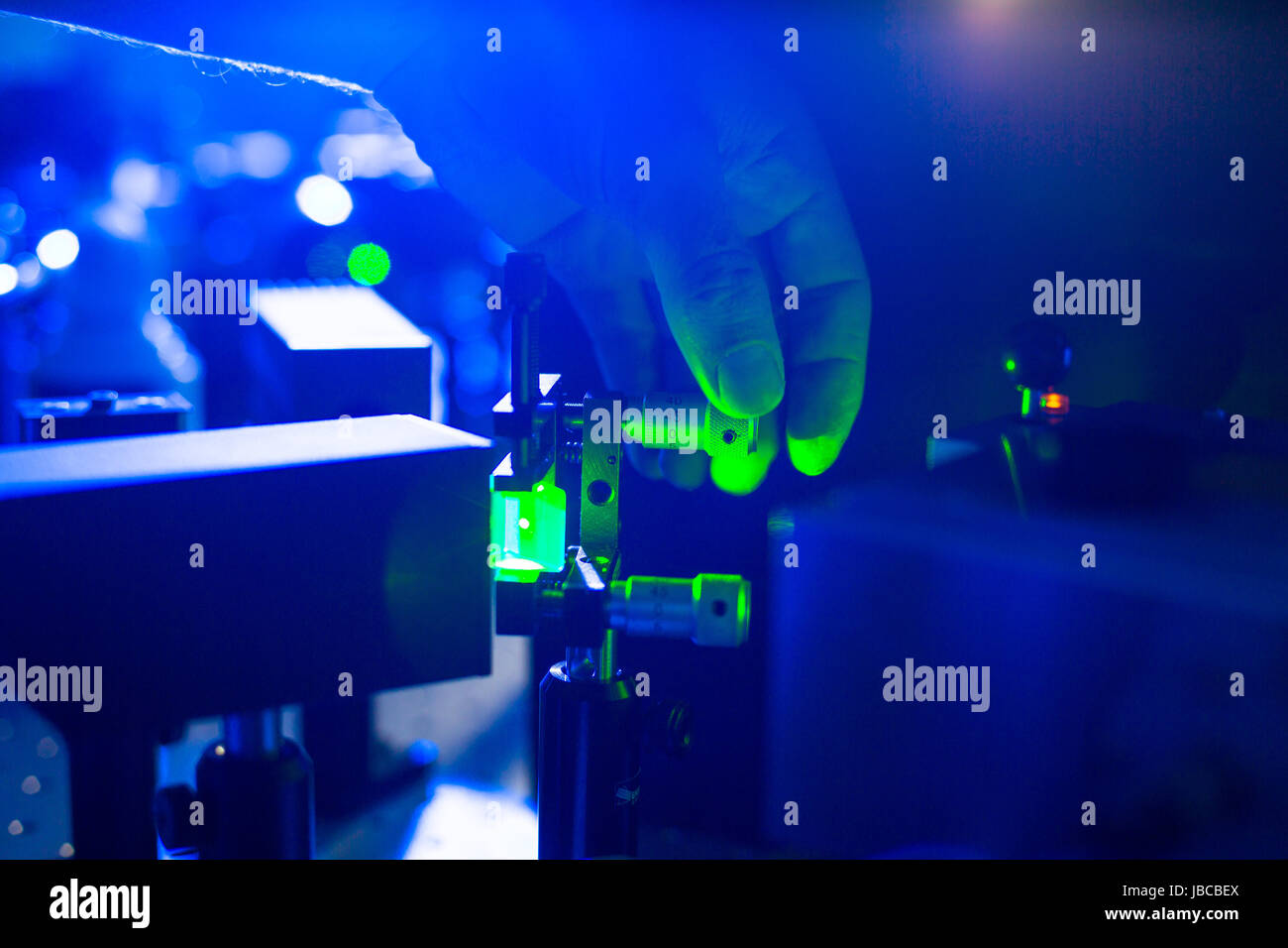Quantum optics hand of a researcher adjusting a laser beam in a lab