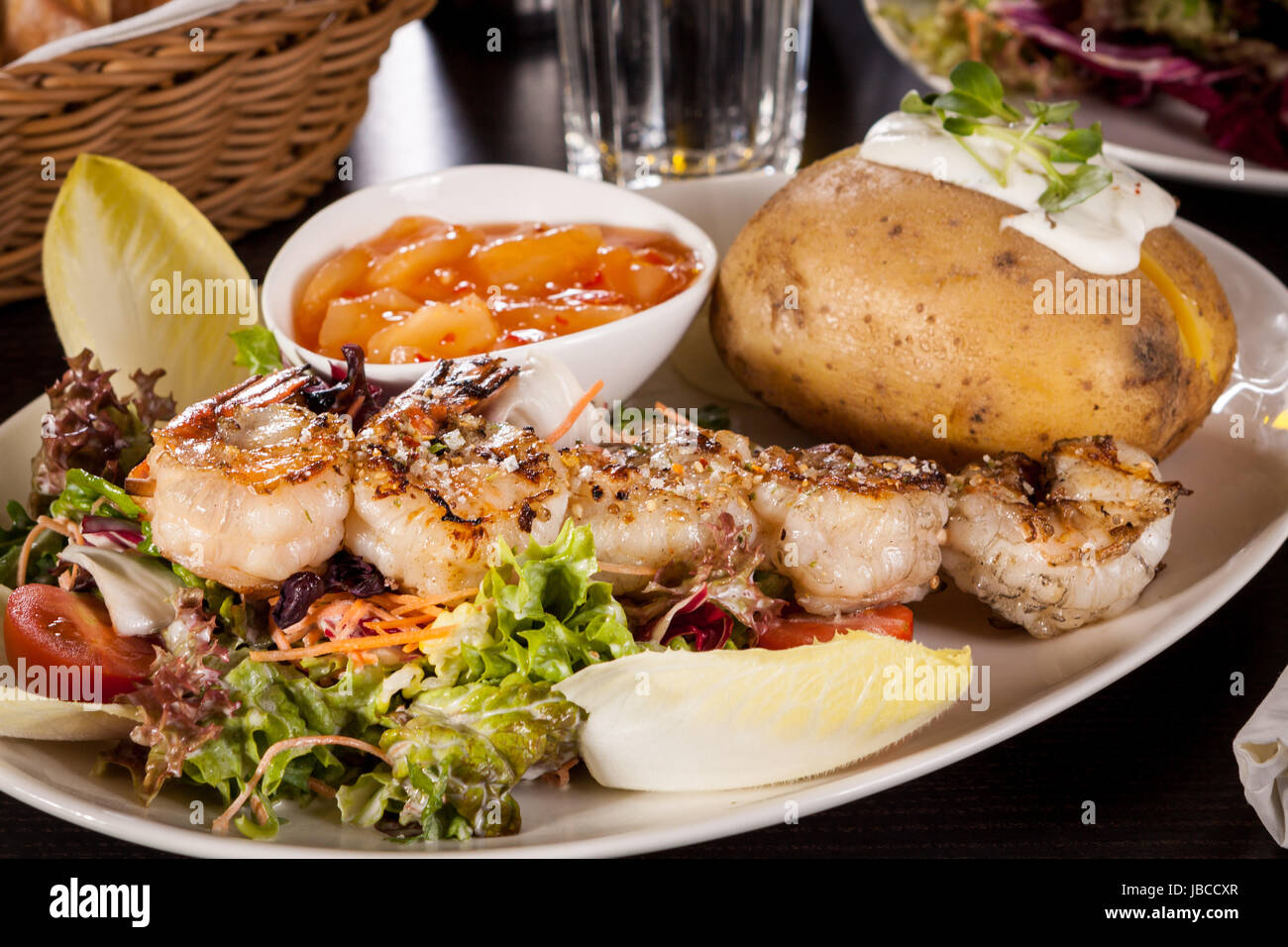 Gebratene Garnelen am Spieß auf gemischtem Salat mit Dipp und ...
