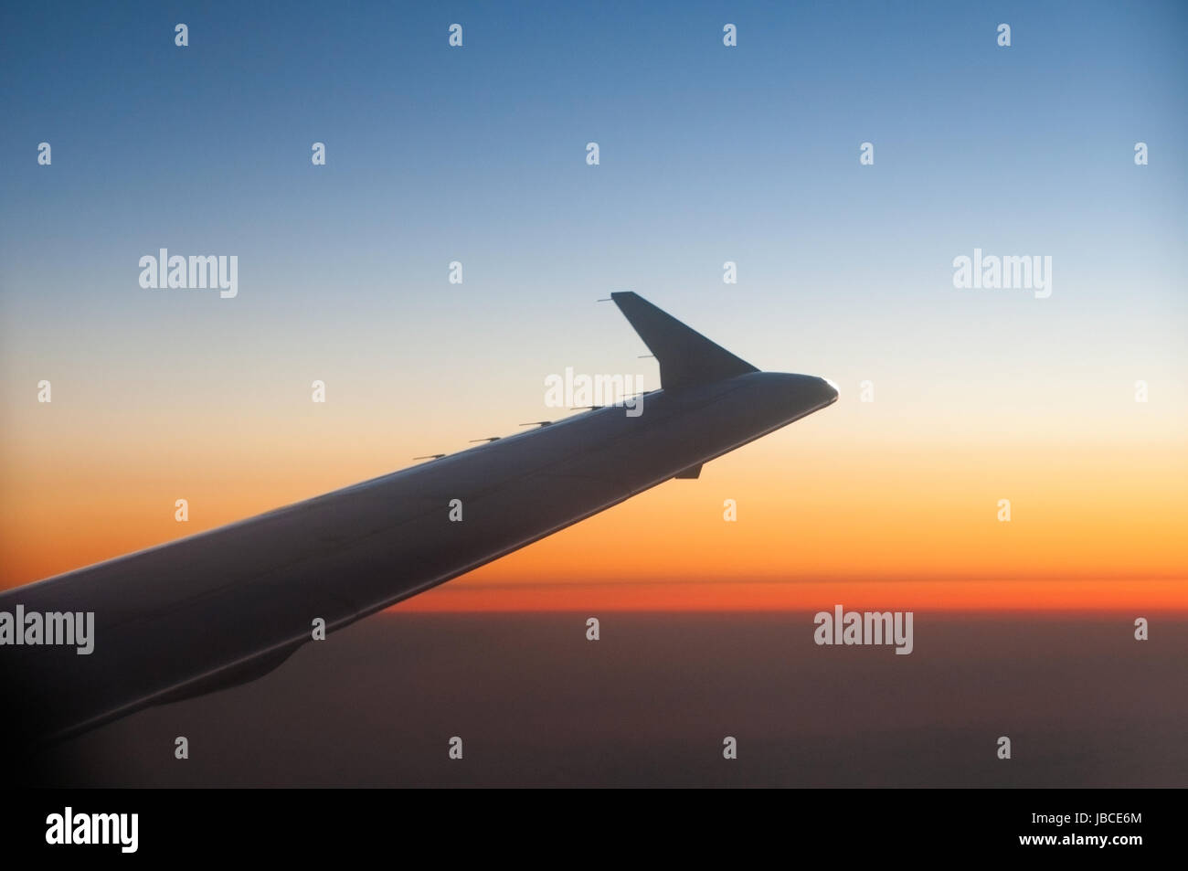 Wing of a Airplane at sunset with clouds Stock Photo - Alamy
