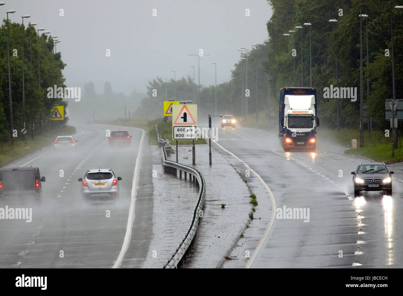 Motoristes tackling the wet summer driving along the A55 dual carridgeway near Halkn, Flintshire, Wales, UK Stock Photo