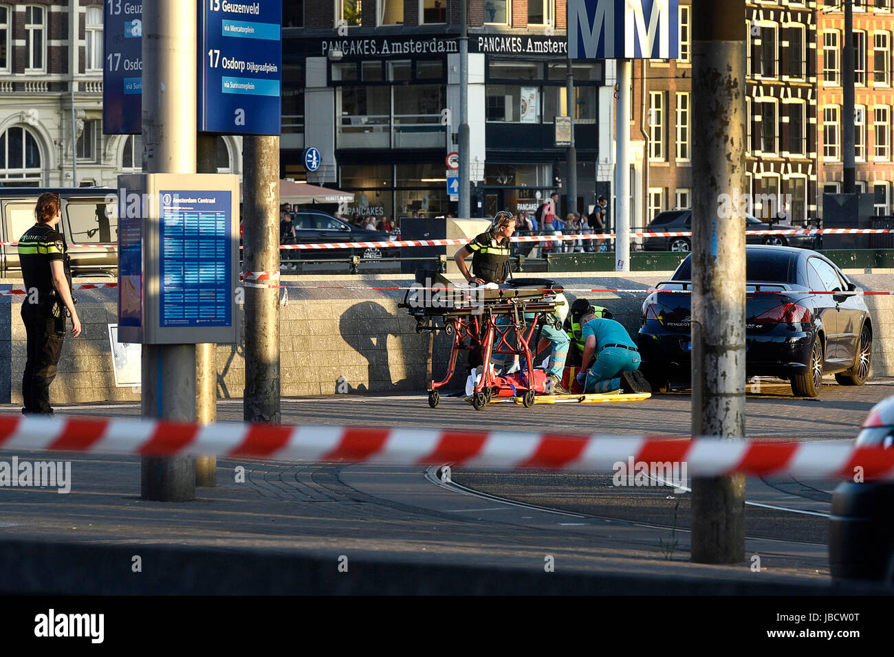 Amsterdam, Netherlands. 10th June, 2017. Rescuers treat an injured person near the site of a car crash in Amsterdam, the Netherlands, on June 10, 2017. In front of Amsterdam Central Station a car hit pedestrians and crashed against a wall at around 9 p.m. local time, injuring eight people, Amsterdam police said on Saturday. Credit: Rick Nederstigt/Xinhua/Alamy Live News Stock Photo