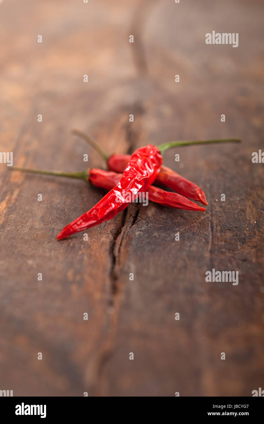 dry red chili peppers over old wood table Stock Photo - Alamy