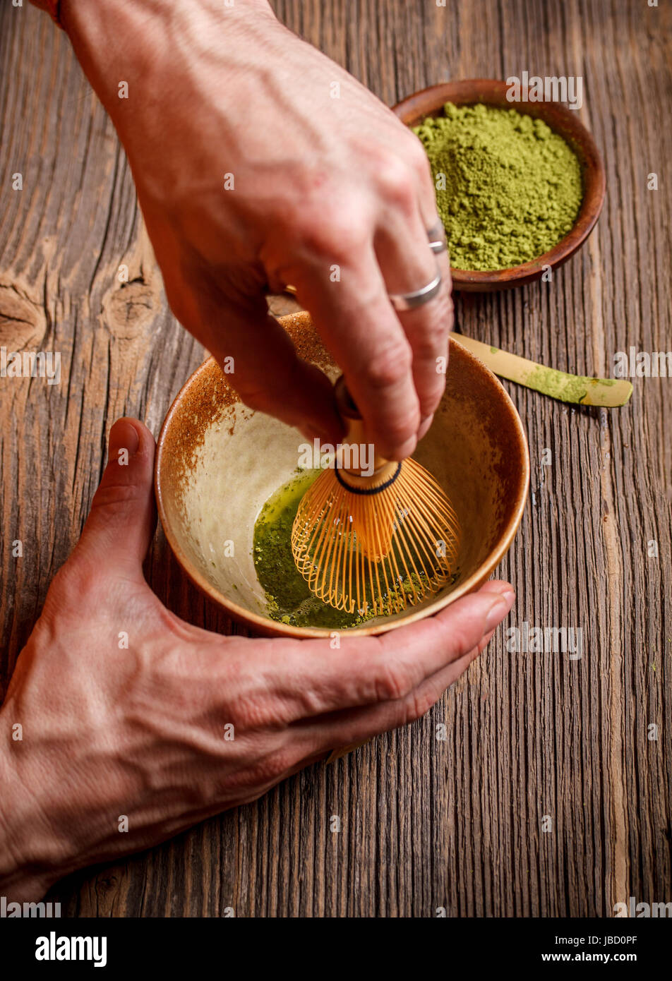 Stirring green tea with tea whisk Stock Photo