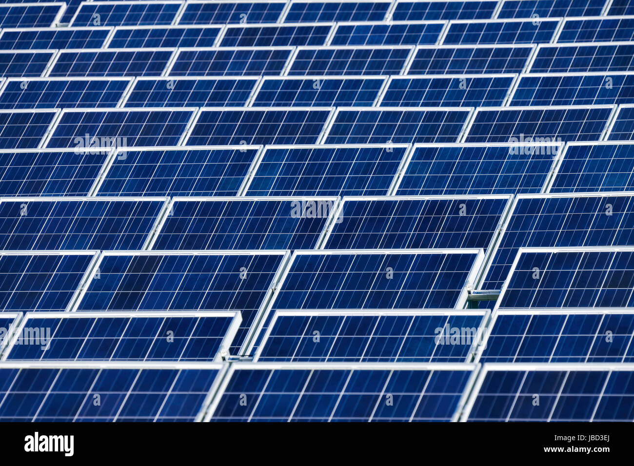 Große Solarkollektoren in Reih und Glied in einem Solarkraftwerk Stock Photo