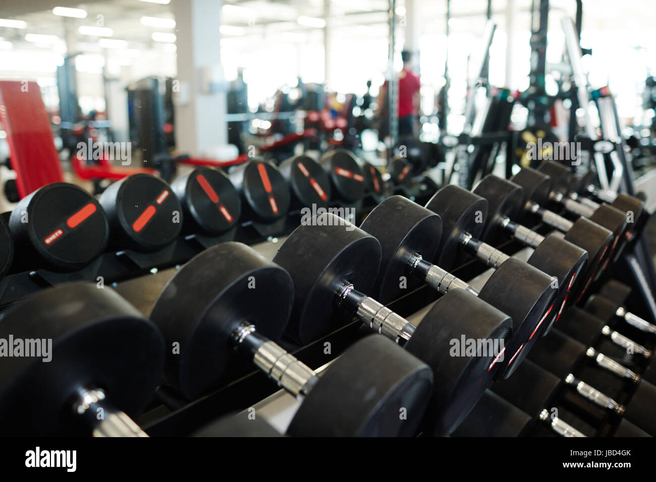 Background image: row of dumbbells on rack in empty modern gym Stock ...