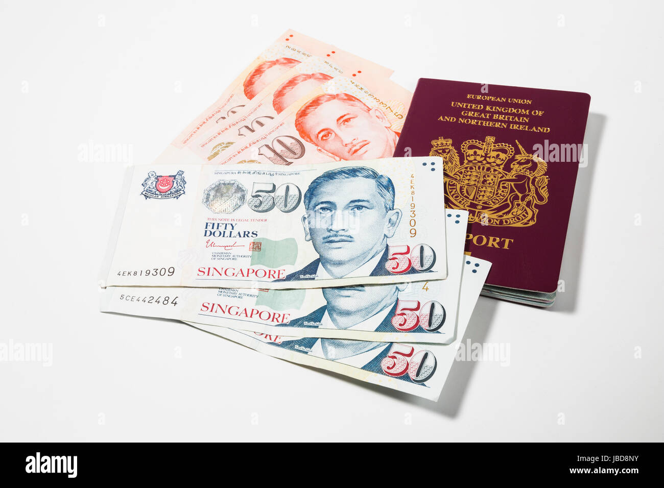 Singapore Dollars and UK Passport Stock Photo