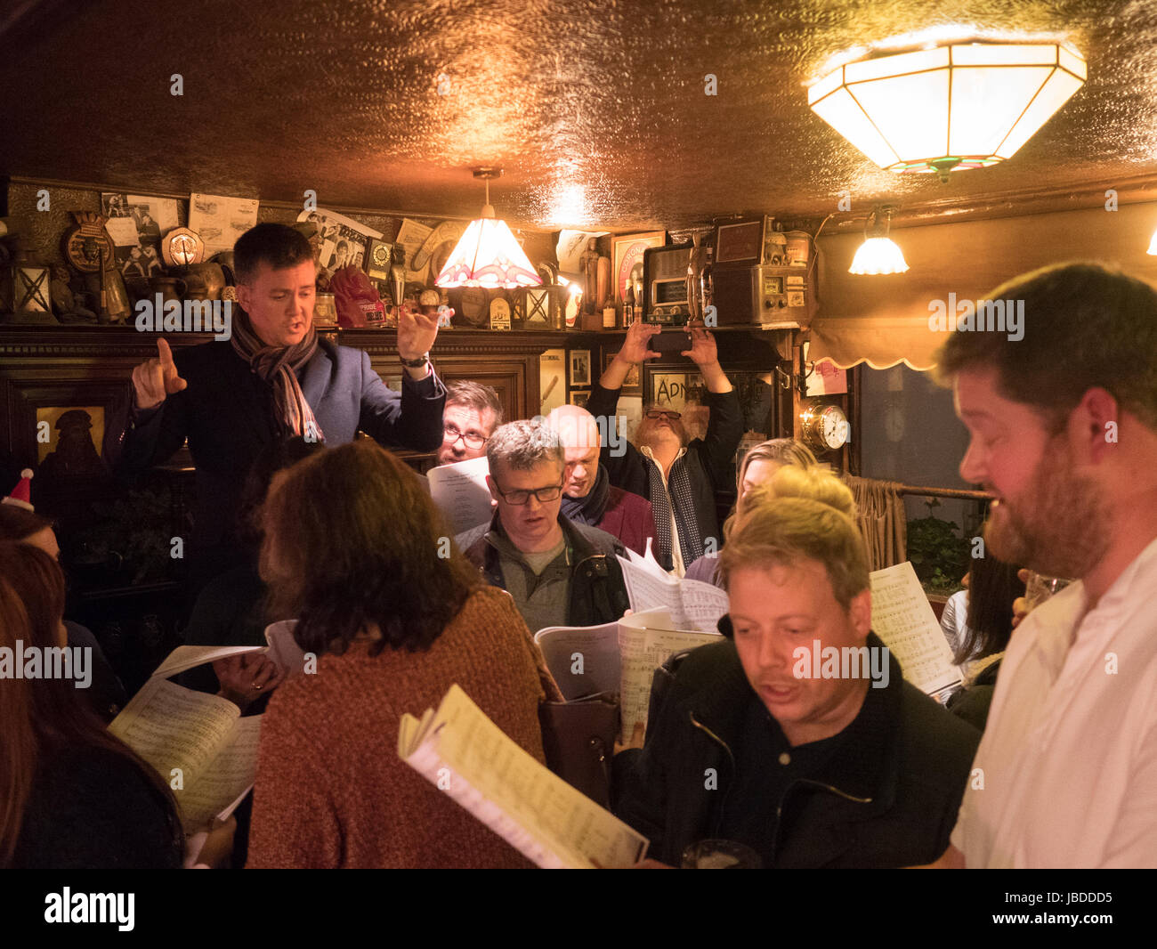 Traditional Christmas Carole singers in the bar of the Nag's Head in London Belgravia Stock Photo