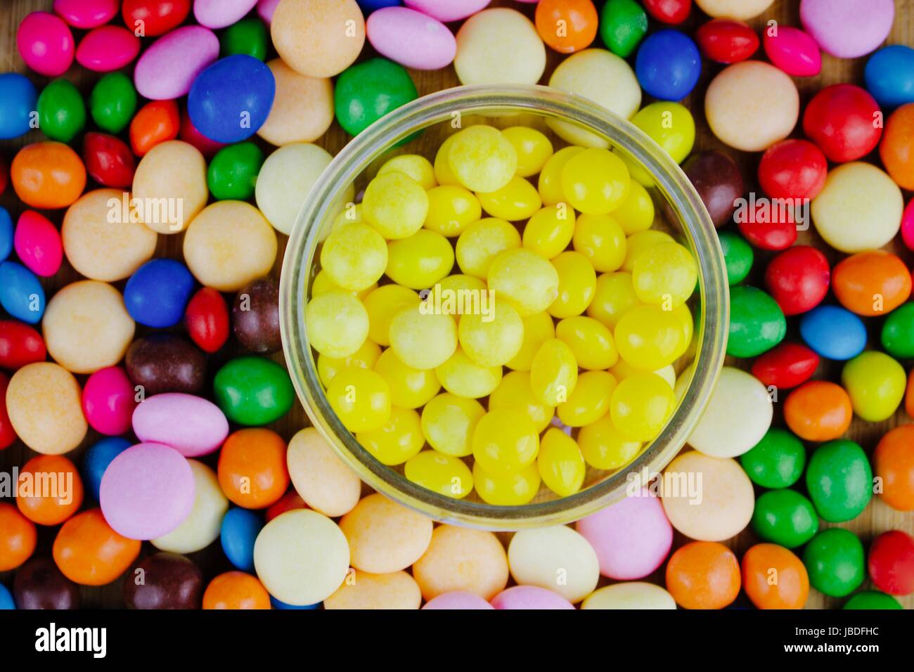 Small yellow sweets in the jar near colored sweets Stock Photo Alamy