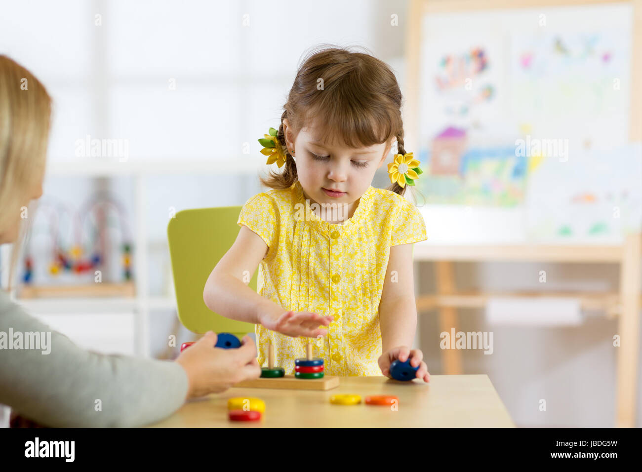Kid is playing with toys in nursery Stock Photo