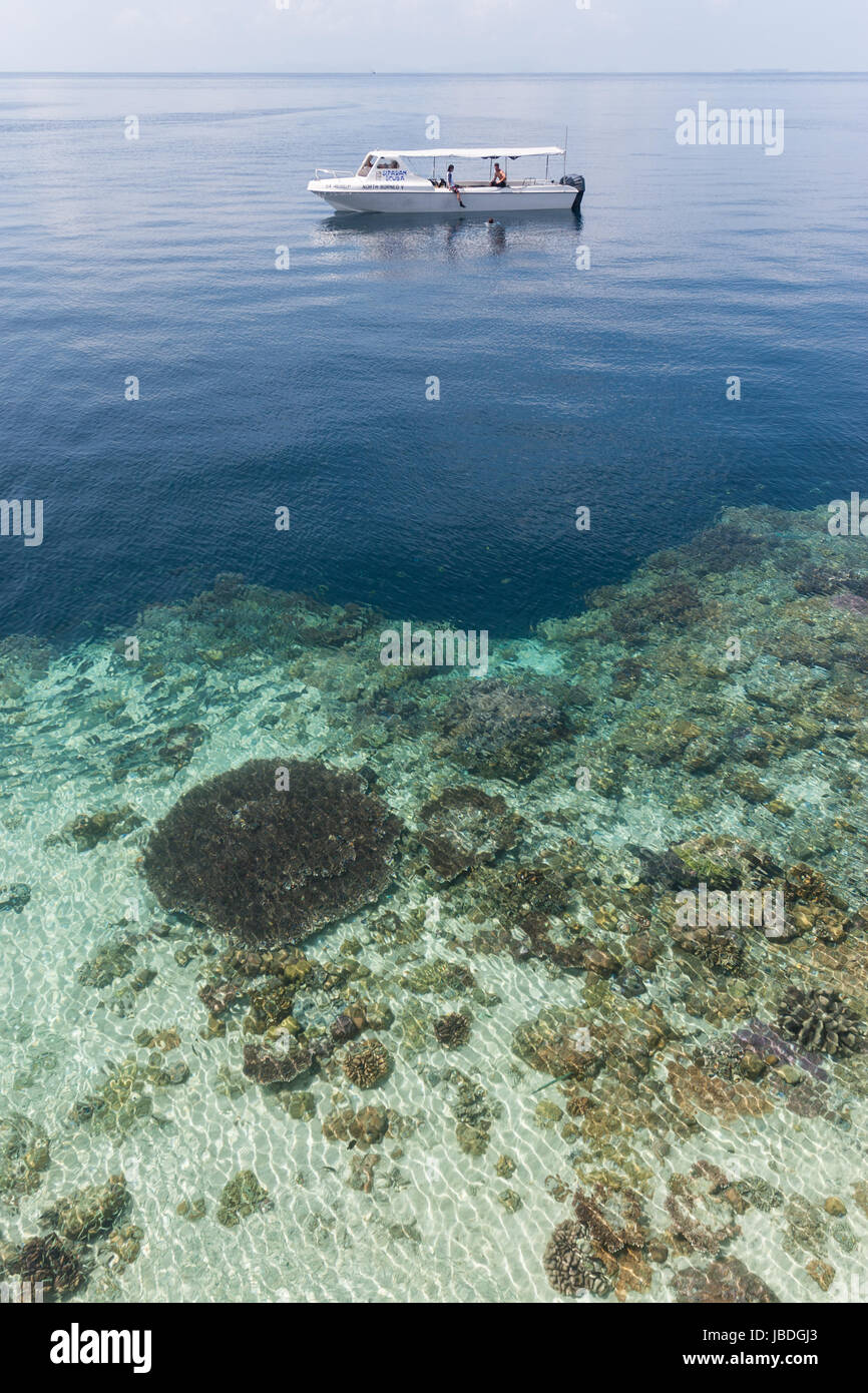SIPADAN, BORNEO, MALAYSIA - A ship used for scuba divers floating in front of coral reef. Stock Photo