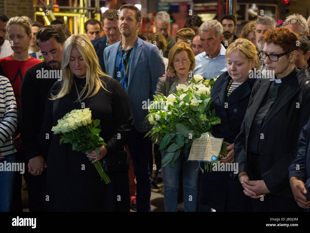 Staff and traders from Borough Market observe a minute's silence before laying flowers outside the market one week after the terrorist attack on London Bridge and Borough Market. Stock Photo