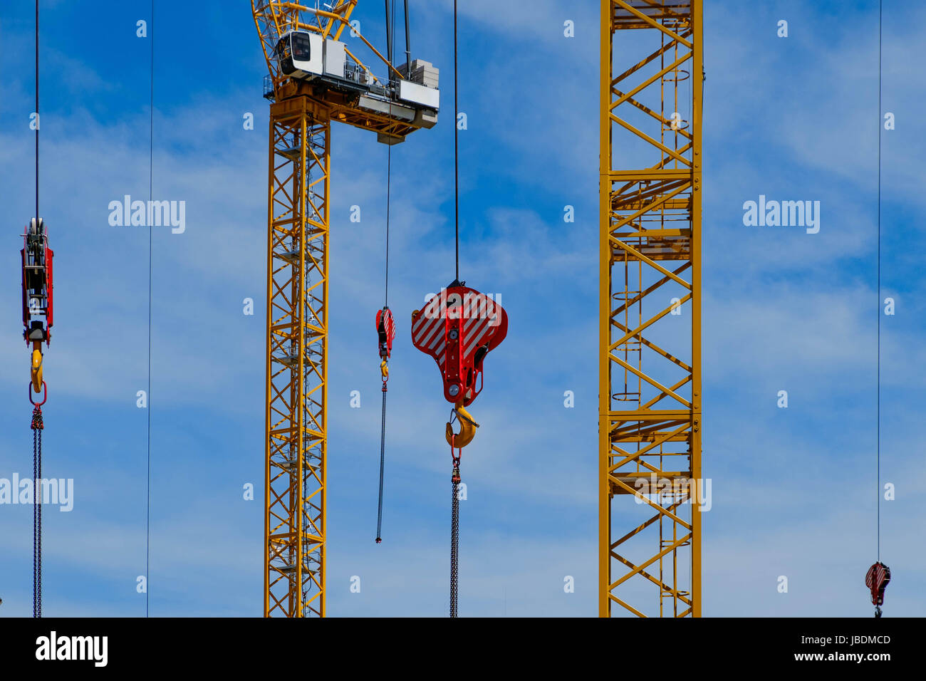 many yellow construction cranes on blue sky backgrounds Stock Photo