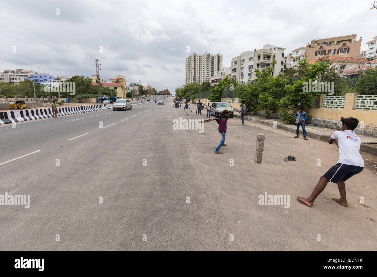 Indian kids playing cricket on a busy street in Hyderabad,India Stock Photo