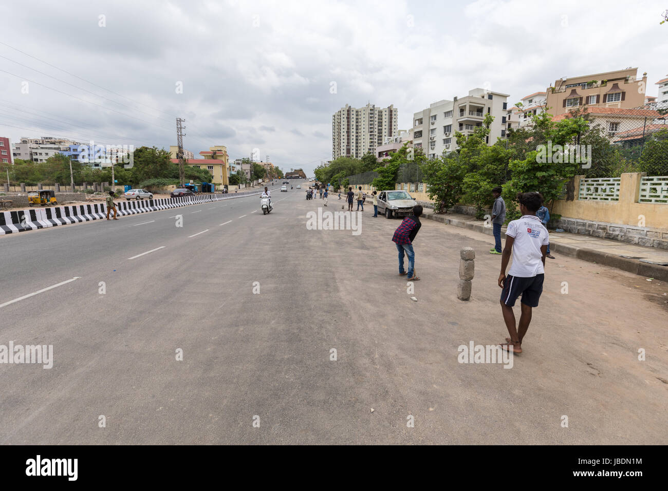 Indian kids playing cricket on a busy street in Hyderabad,India Stock Photo