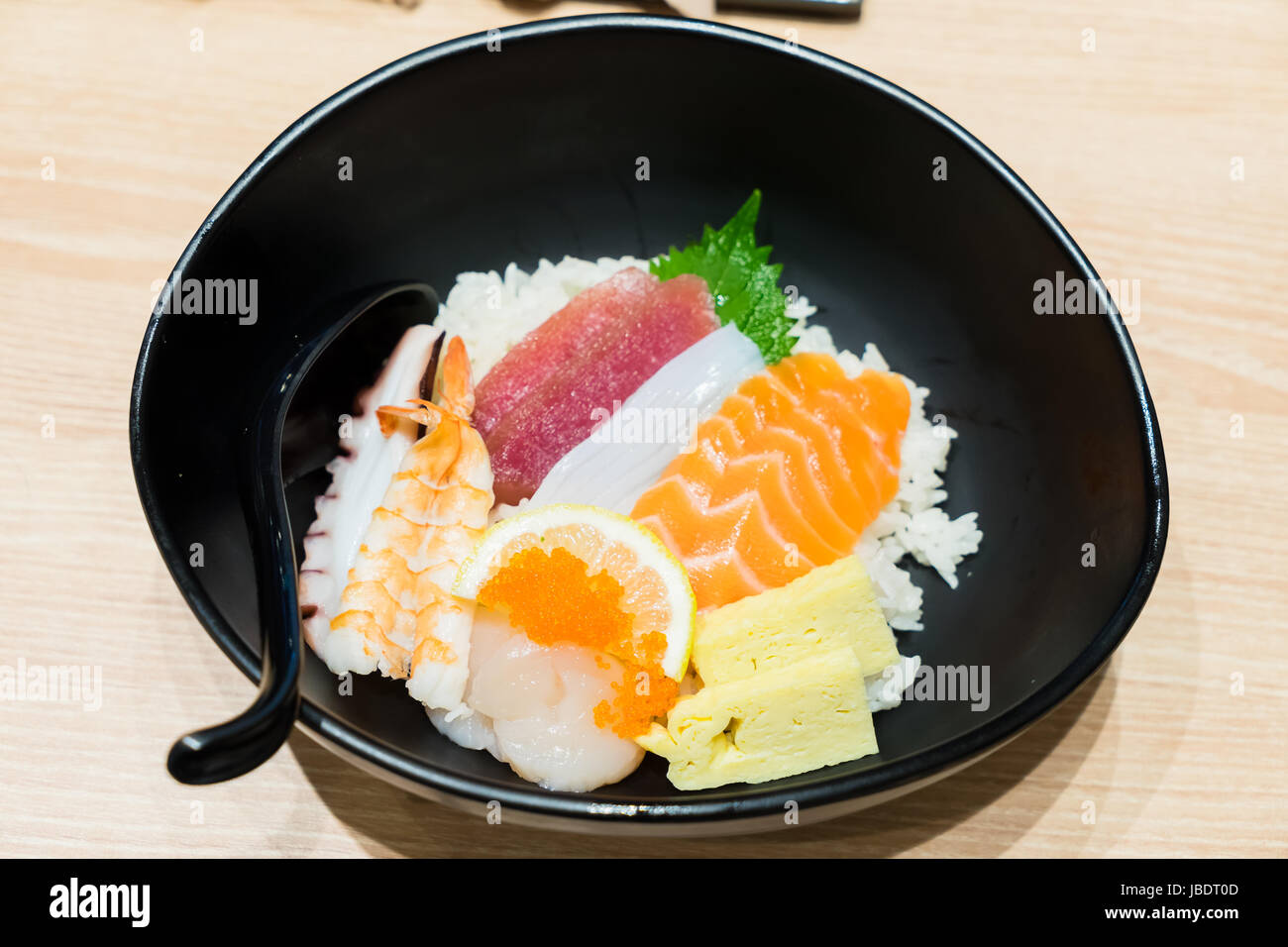Chirashi Sushi bowl with salmon, tuna, shrimp, scallops, sea bass, sweet omelette served with Wasabi Stock Photo
