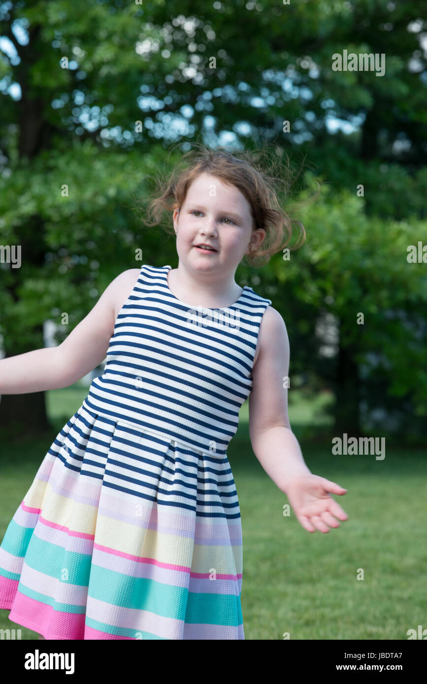Portrait of Young Girl Standing in Backyard Stock Photo