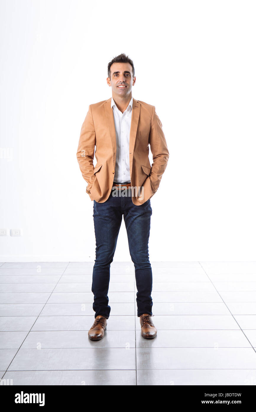A 35 - 40 years man caucasian dark hair cool modern informal look blazer, arms folded smiling white background studio full shot Stock Photo