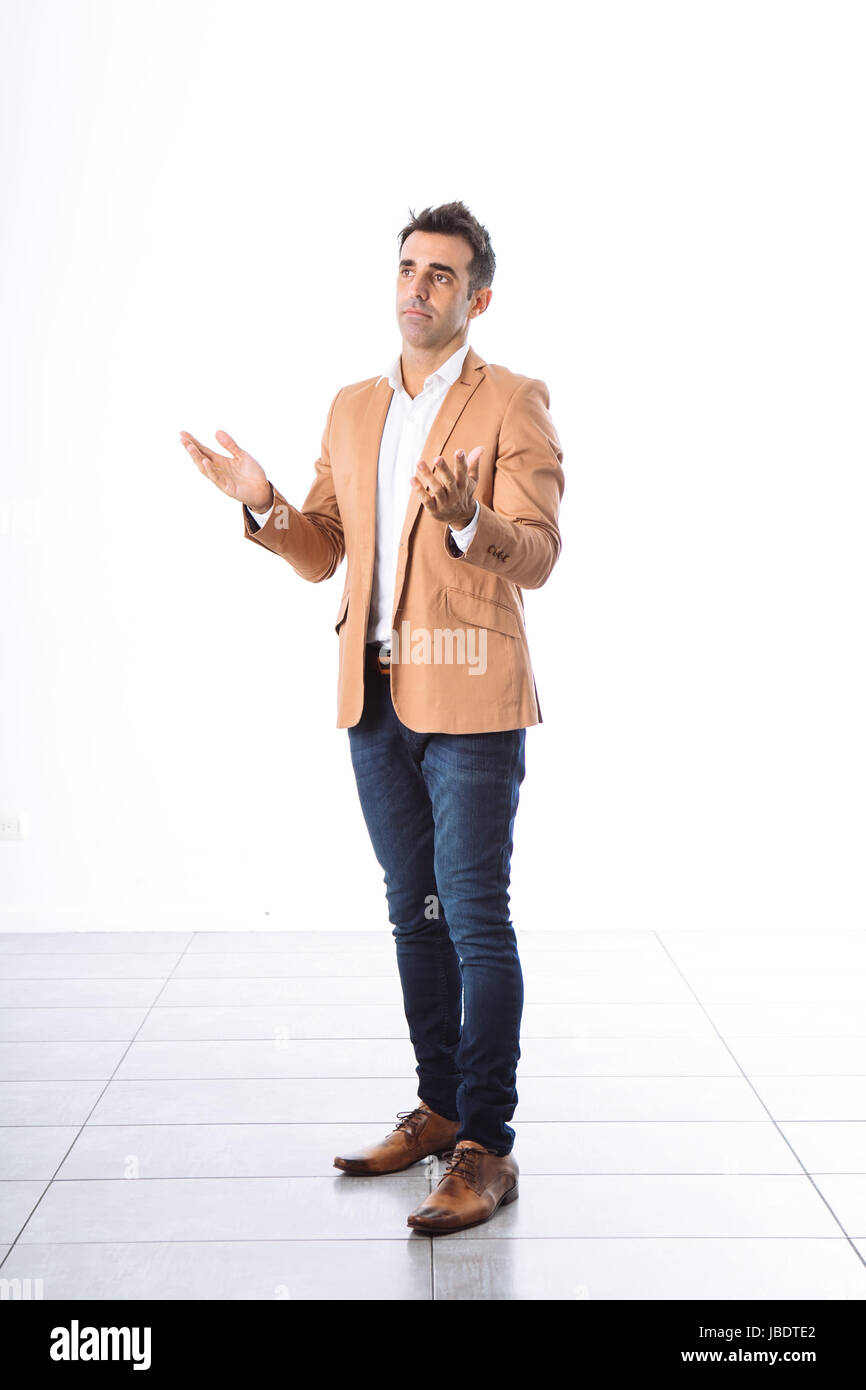 A 35 - 40 years man caucasian dark hair cool modern informal look blazer, moving arms explaining white background studio full shot Stock Photo