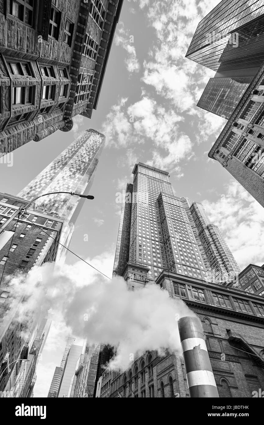 Looking up at Manhattan skyscrapers with steam coming from street pipe, New York City, USA. Stock Photo