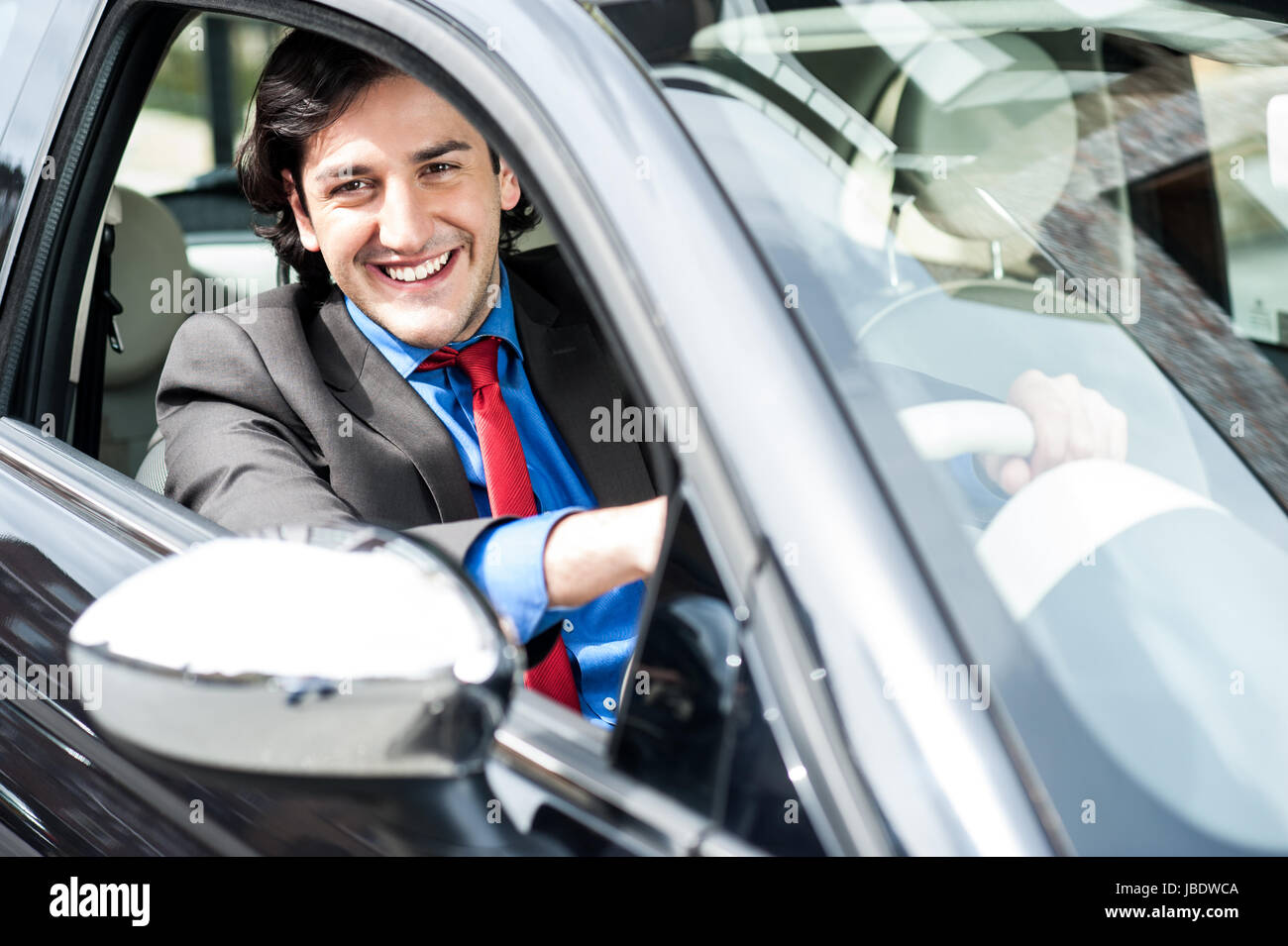 Handsome businessman driving a luxurious car Stock Photo - Alamy