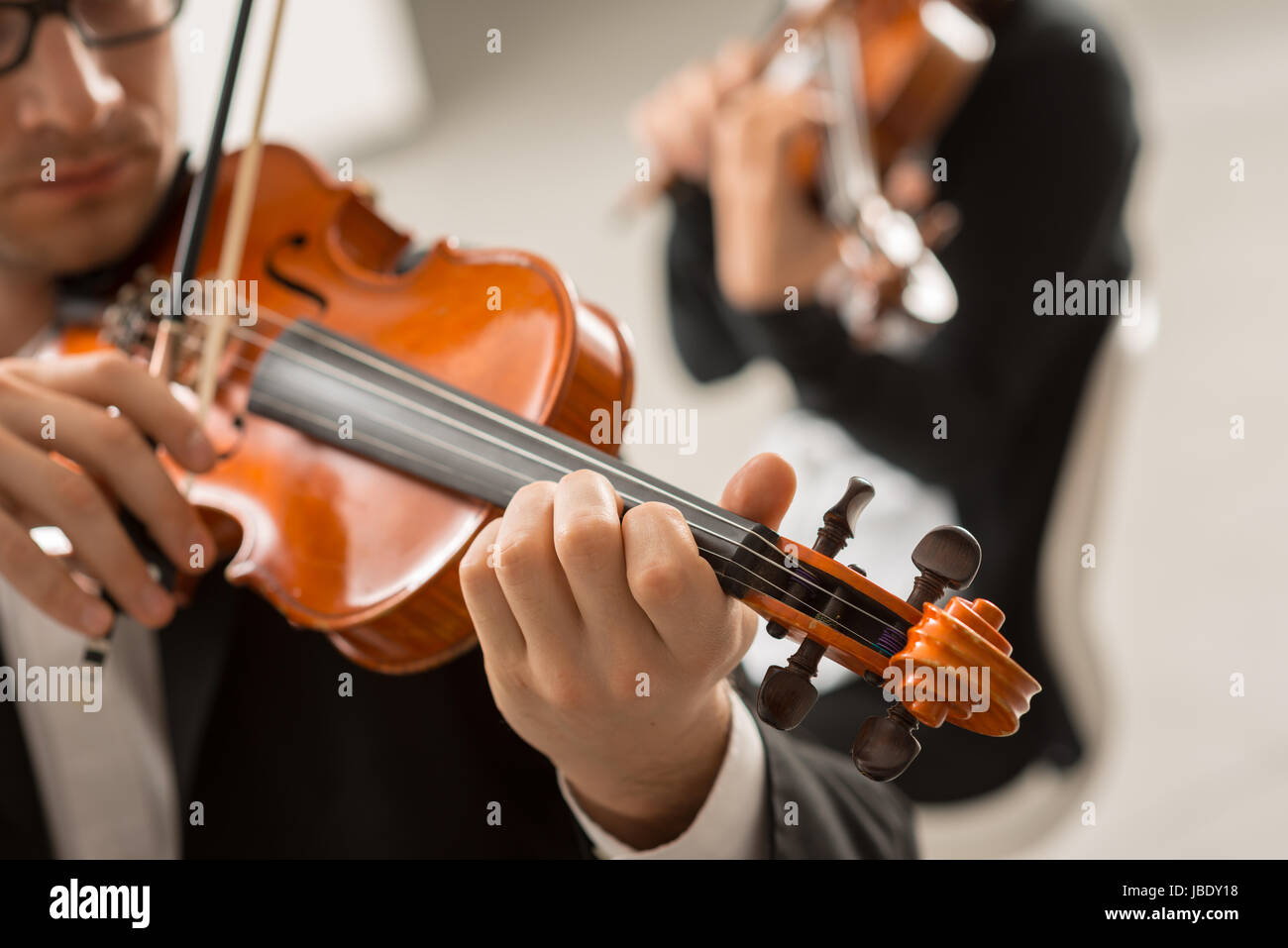 Two violinists performing together hands close up, classical music