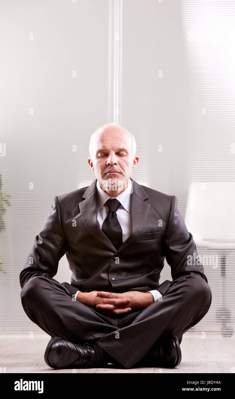 relaxed businessman meditating with the leg crossed Stock Photo - Alamy