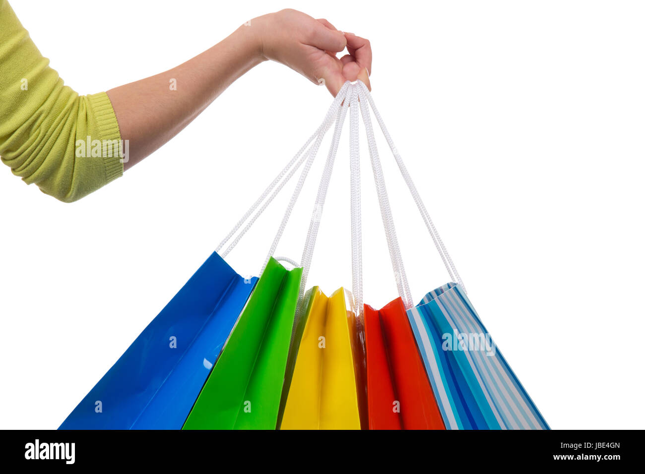 Eine junge Frau hält Einkaufstaschen fürs Shopping in der Hand, isoliert vor einem weissen Hintergrund Stock Photo