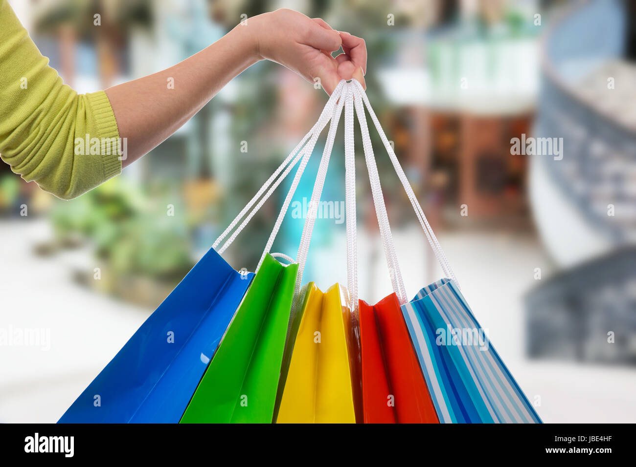 Eine junge Frau hält Einkaufstaschen fürs Shopping in der Hand in einer Shopping Mall Stock Photo