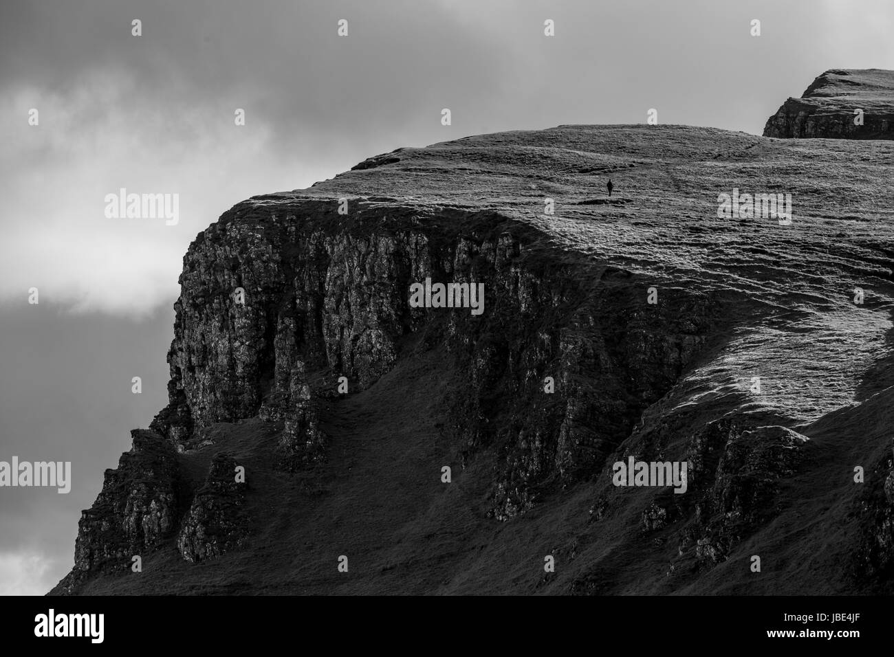 one person walking on a rock formation at quiraing pass in scotland isle of skye Stock Photo