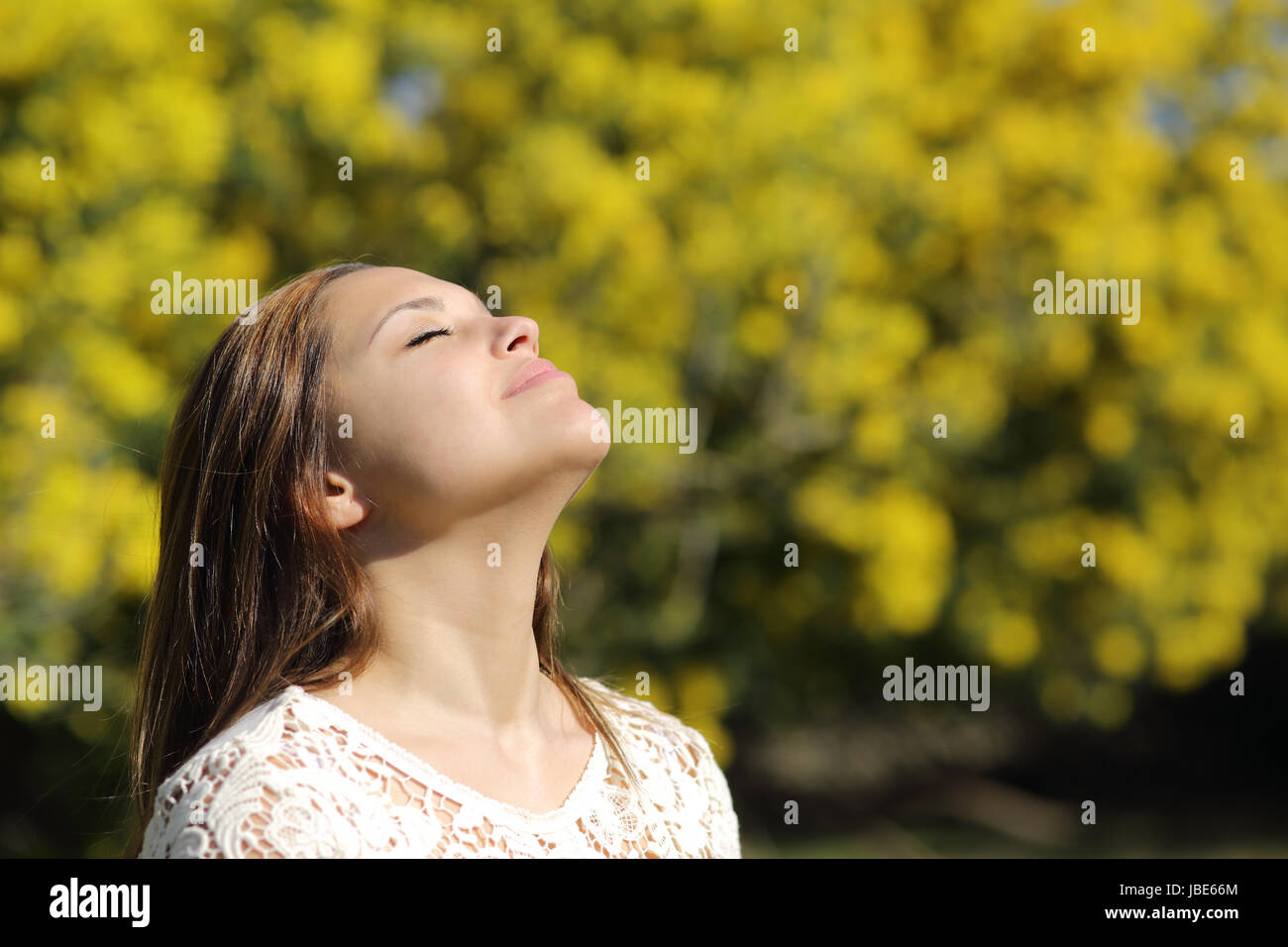 Spring Breathaking Woman breathing deep in spring or summer with a yellow background Stock ...
