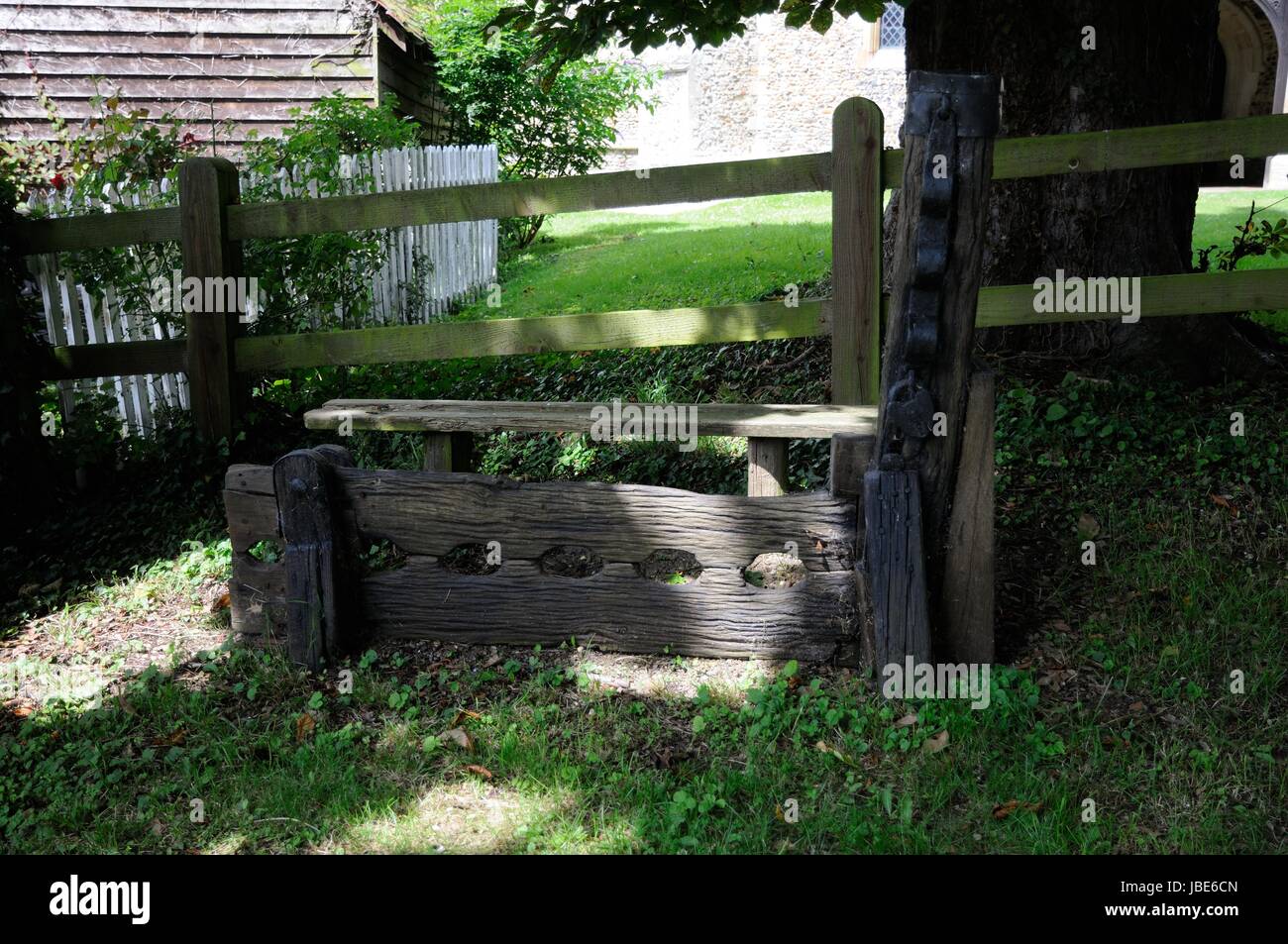 The Stocks and Whipping Post, Brent Pelham, Hertfordshire, are just outside the churchyard shaded by trees Stock Photo