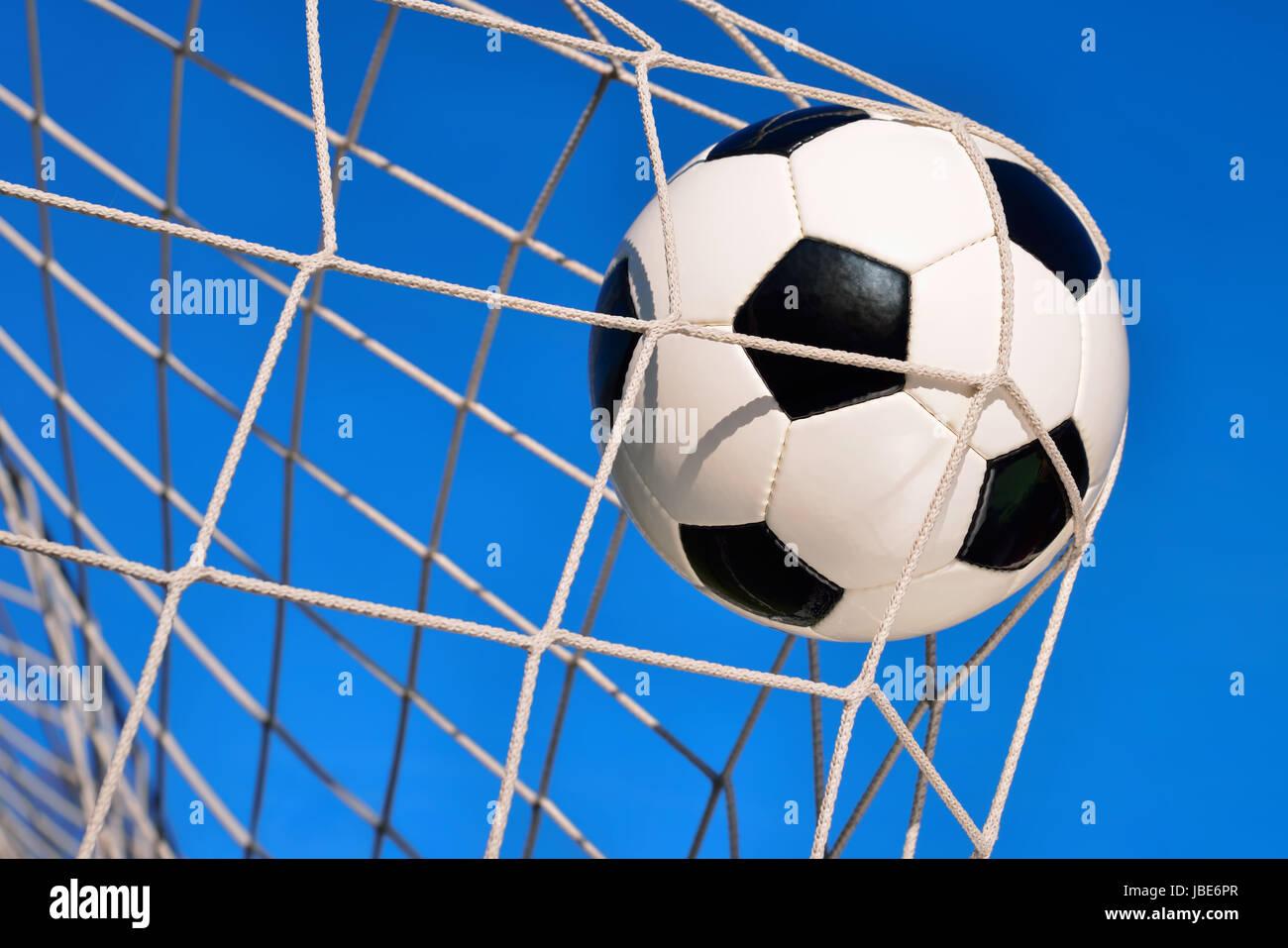 Fußball fliegt vor klarem blauen Himmel ins Tor Stock Photo