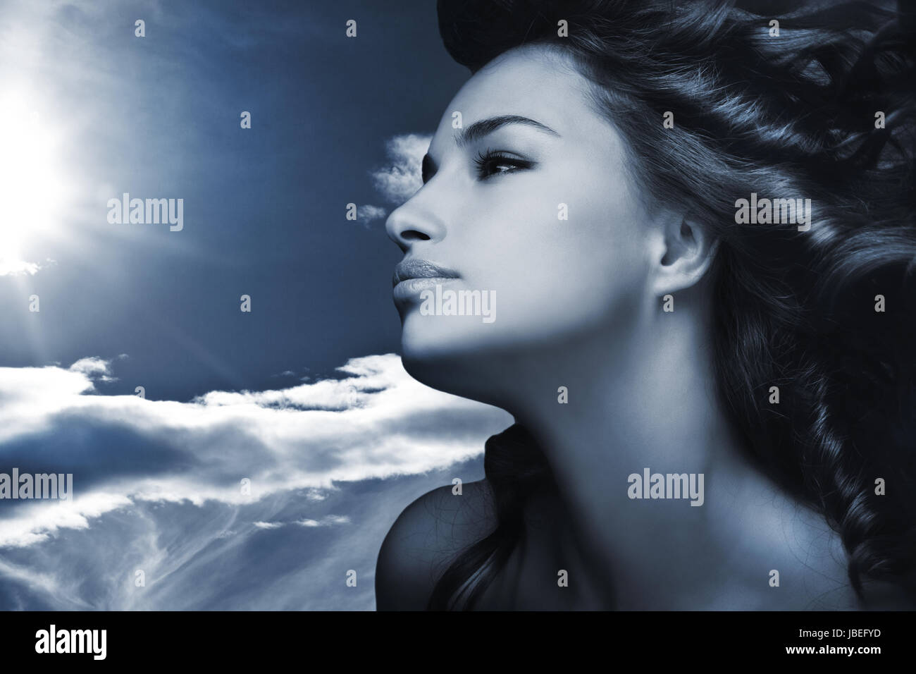beautiful young woman with sky and sun in background blue color Stock ...