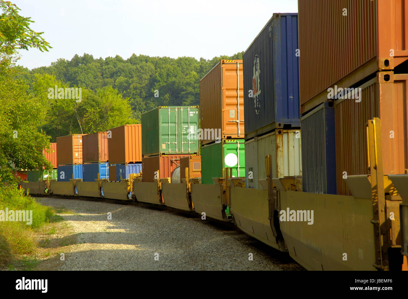 A long freight train with many boxcars hauls goods of various types to ...