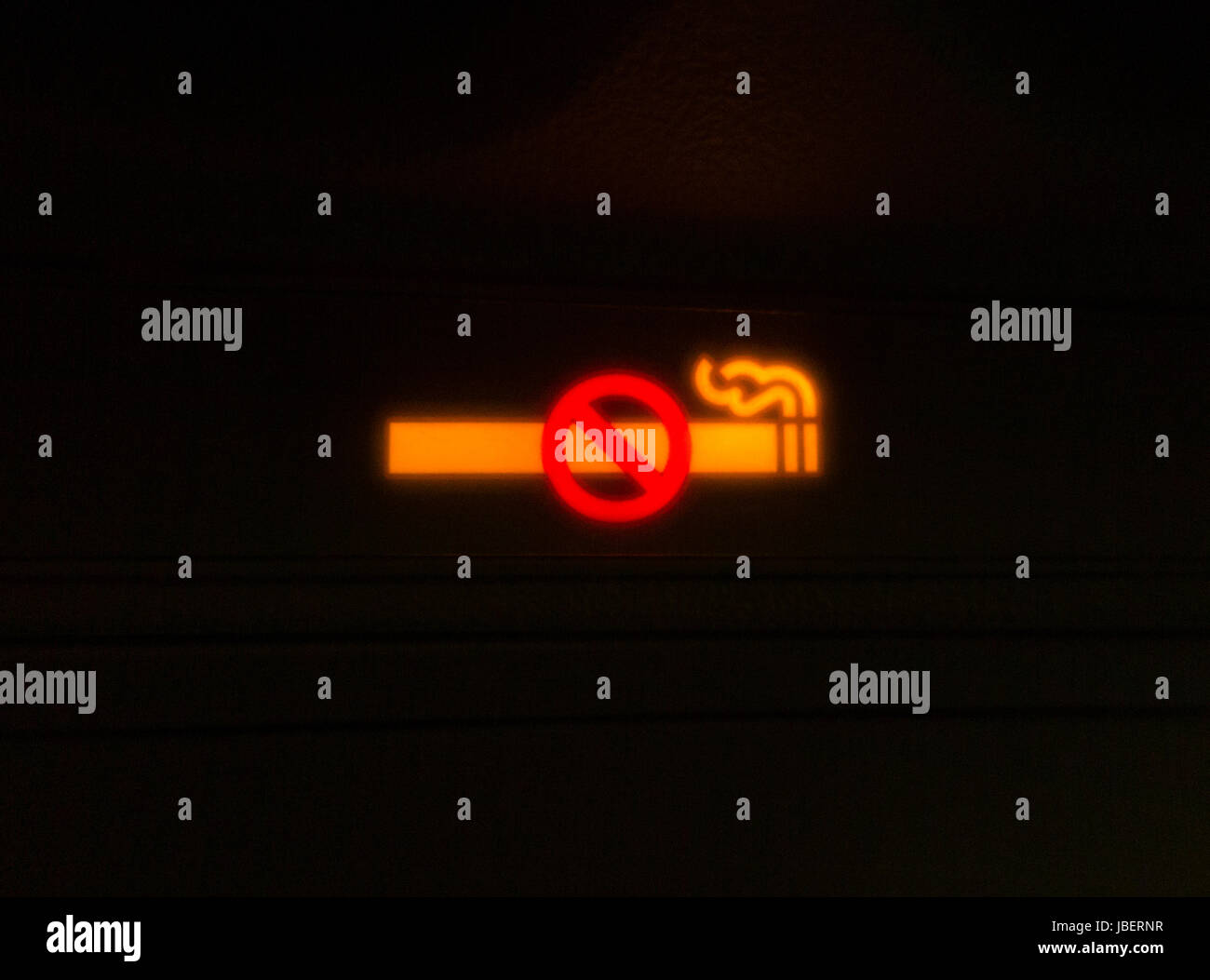 Aircraft no smoking / non / none cigarette sign lit up and illuminated during a flight on a passenger plane / aeroplane/  airplane. Stock Photo