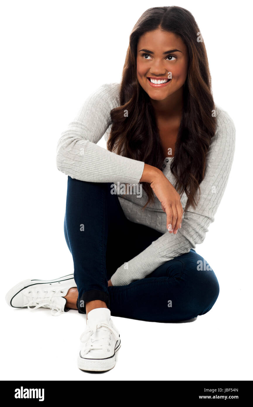 Attractive smiling girl sitting on the floor looking up Stock Photo - Alamy