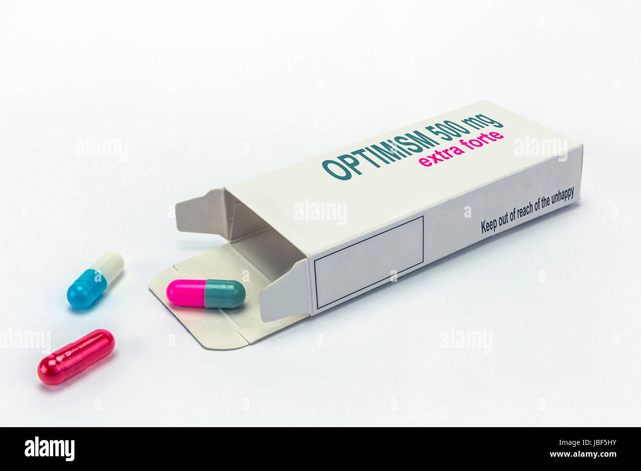 Open medicine packet labelled optimism opened at one end to display a blister pack of tablets, isolated on white Stock Photo