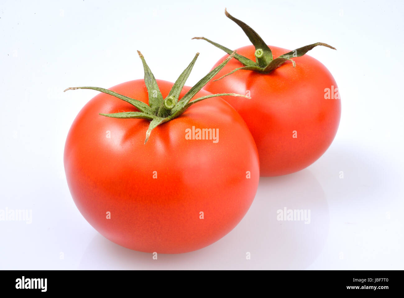 pair of red and ripe tomatoes on a white background Stock Photo - Alamy