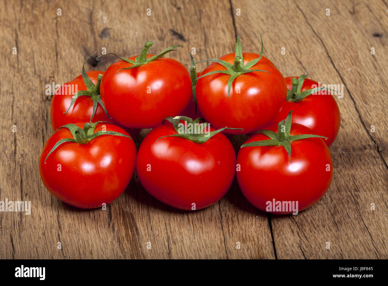 Ein Haufen reifer Tomaten auf einem Holztisch Stock Photo