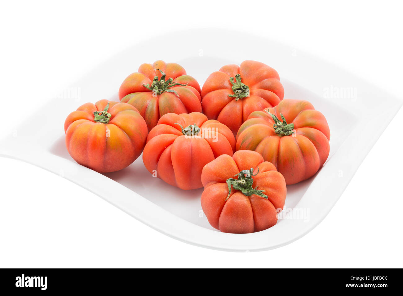 Ganze Tomaten auf weißem Teller Stock Photo